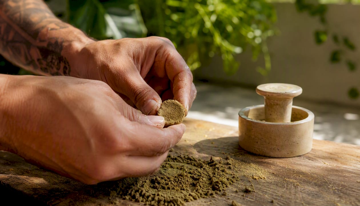 Hands pressing kief into hash on wood