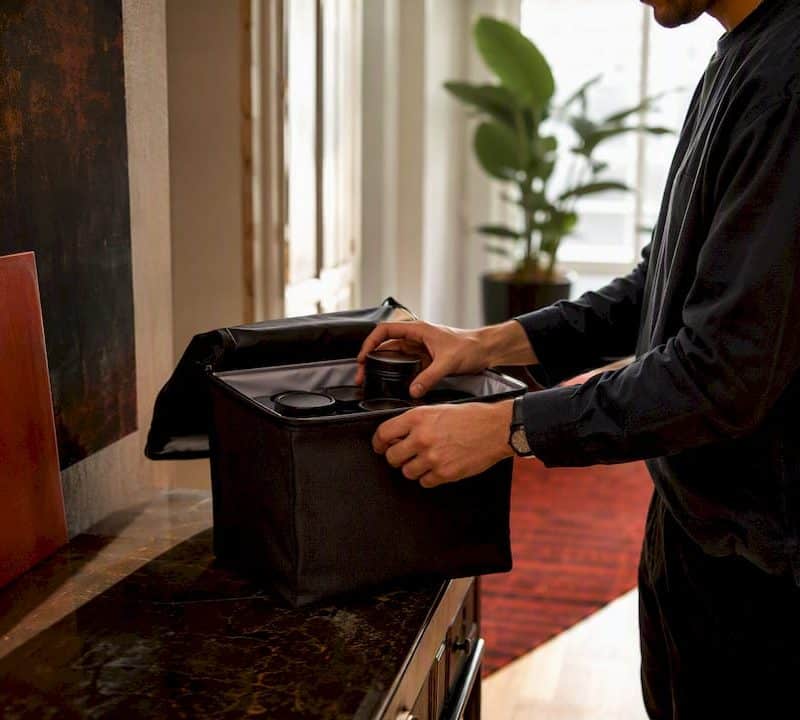Hands preparing cannabis delivery bag indoors