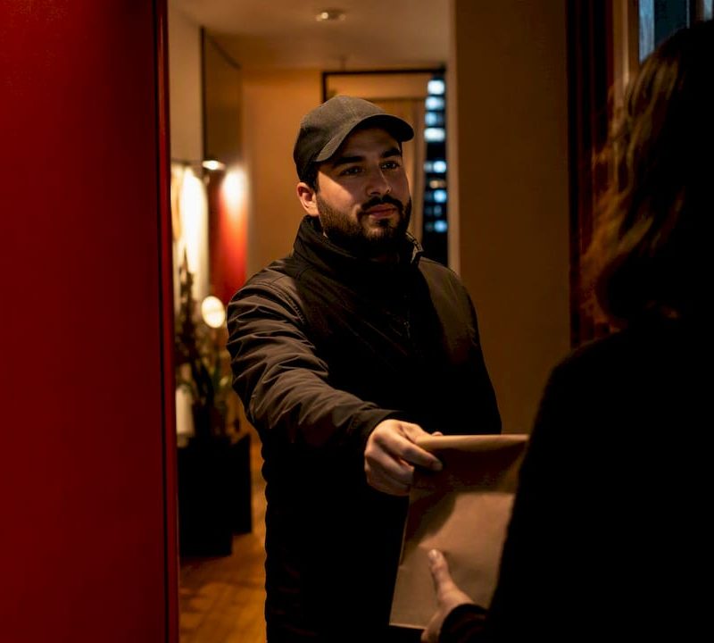 Discreet cannabis delivery handoff at NYC doorway