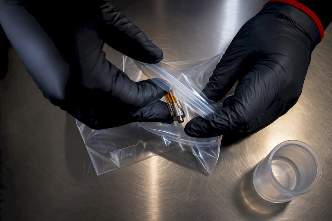 Hand sealing suspicious cartridge in evidence bag