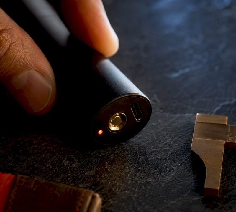 Close-up of anonymous vape battery charging end