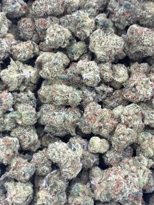 Tightly clustered frosty Blue Dream sativa small buds with sage green tones, amber pistils, and thick trichome coverage